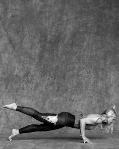 a woman in black and white is doing a split on the ground with her legs spread out