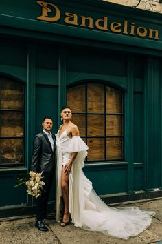 a man and woman standing in front of a building