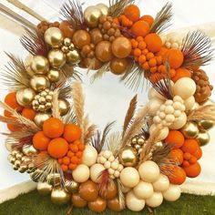 an orange and white wreath with gold ornaments