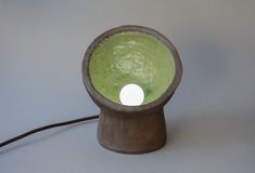 a lamp that is on top of a wooden stand with a white light in the middle