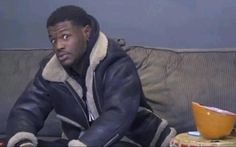 a man sitting on top of a couch next to a bowl