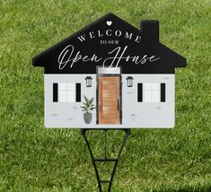 an open house sign with a potted plant in the front and welcome to our open house written on it