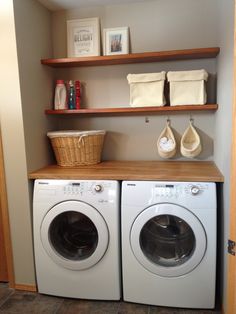 a washer and dryer sitting in a room next to each other with shelves above them