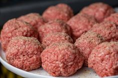 a white plate topped with meatballs covered in seasoning on top of a table