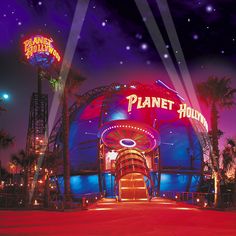 the planet hollywood sign is lit up at night with palm trees and neon lights around it