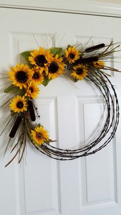 a wreath with sunflowers is hanging on the front door