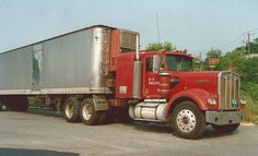 a red semi truck is parked on the side of the road