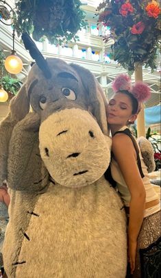 a woman is hugging a giant stuffed animal