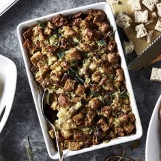 a casserole dish with meat and vegetables in it on a table next to other dishes