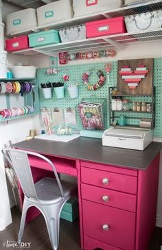 a pink desk with lots of crafting supplies on the top and shelves above it