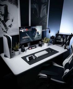 a desk with two computer monitors and a keyboard on it, in front of a black wall