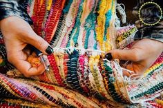 a person is holding some colorful bracelets in their hands and they are weaving them together