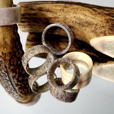 an assortment of rings are displayed in front of a banana peel and other wood objects