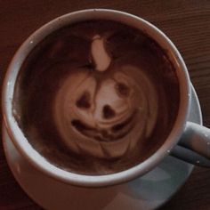 a coffee cup with a smiley face drawn on the foam in it's bottom