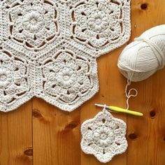 the crocheted doily is laying on the floor next to yarn and scissors