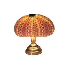 a lamp that is sitting on top of a tablecloth covered flooring area with an orange, yellow and red design