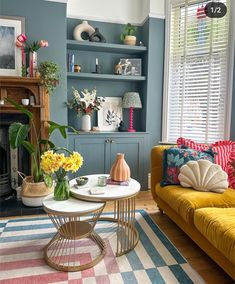 a living room filled with furniture and flowers on top of a table in front of a fire place