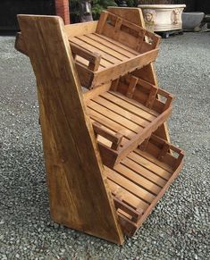 a wooden shelf sitting on top of a gravel covered ground