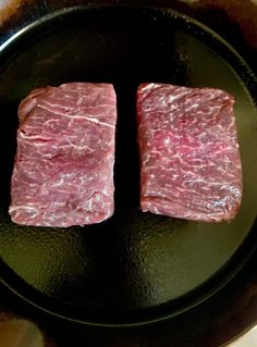 two pieces of raw meat in a frying pan