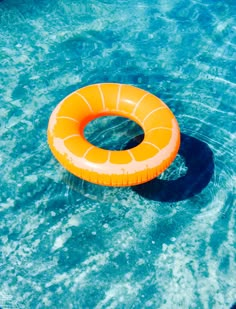 an inflatable ring floating on top of a pool with clear blue water and ripples