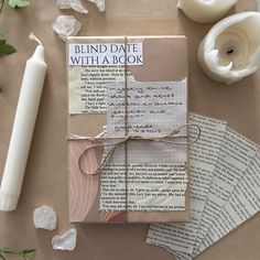 an open book sitting on top of a table next to some candles and paper with writing