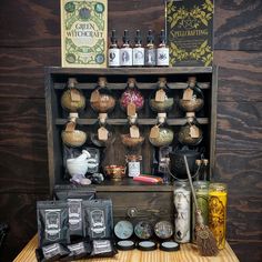 a wooden shelf filled with lots of bottles and jars on top of a table next to other items