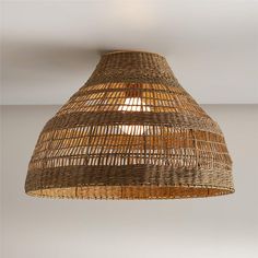 a light that is made out of wicker and hanging from the ceiling in a room