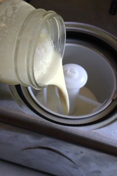 a person pouring milk into a glass container