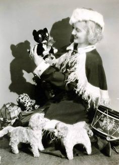 an old black and white photo of a woman with stuffed animals