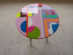 a colorful table with wooden legs on carpeted floor