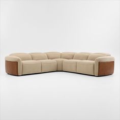 the sectional sofa is made from beige fabric and has brown leather trim on the sides