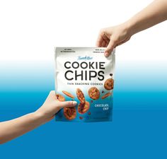 two hands holding up a bag of cookie chips on a blue and white background,