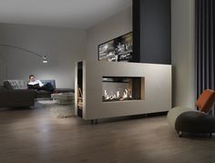 a living room filled with furniture and a fire place next to a wall mounted tv