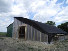 a large metal building with a black tarp covering it