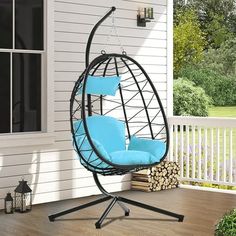 a swing chair with blue cushions on a porch