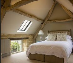 a large bed sitting under a window in a bedroom next to a radiator