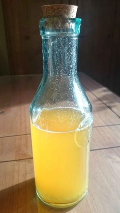 a glass bottle filled with liquid sitting on top of a wooden table