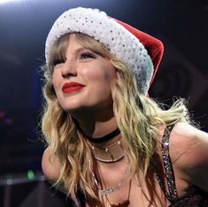 a woman wearing a santa hat on top of her head in front of a microphone