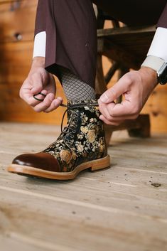 a man tying his shoelaces on top of a wooden floor