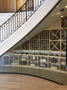 there is a wine rack under the stairs in this building with many bottles on it