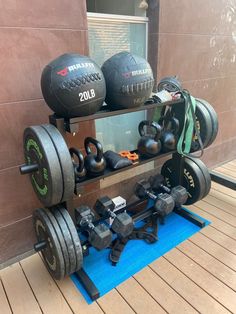 a gym equipment rack with dumbs and exercise balls