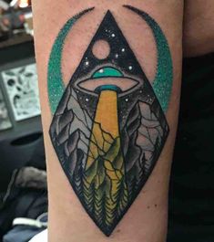 a man with a tattoo on his arm that has an eye in the sky and mountains