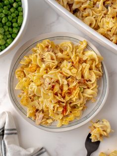 a plate with pasta and peas next to a casserole dish