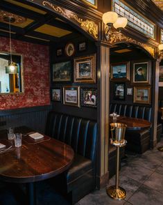 the interior of a restaurant with black leather booths and pictures on the wall behind it