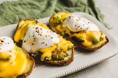 three pieces of bread with cheese and broccoli on them sitting on a plate