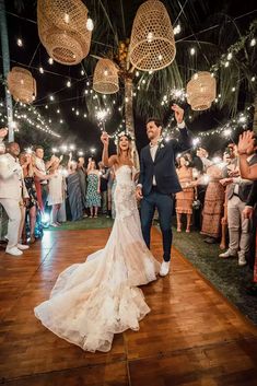 a bride and groom walking down the aisle holding sparklers