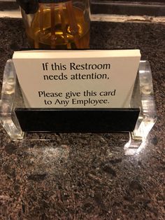 a sign that says if this restroom needs attention, please give this card to any employee