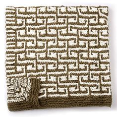 a brown and white knitted blanket sitting on top of a table