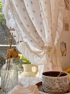 there is a cup and saucer sitting on the table next to the window sill