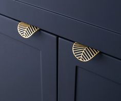 a close up view of the handles on a blue cabinet with gold leaf knobs